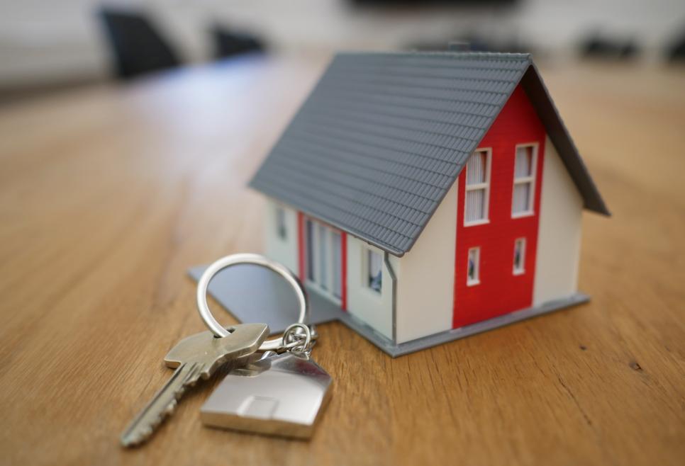 Model of a house and keys in front of it