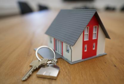 Model of a house and keys in front of it